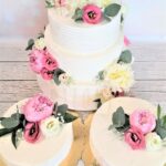 Piękny tort ślubny ozdobiony żywymi kwiatami